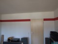 Ein Rundblick ums Wohnzimmer mit der roten Tapete. 3